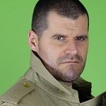 Steve Tait, A man in a tan jacket staring fiercly in the camera with a green background