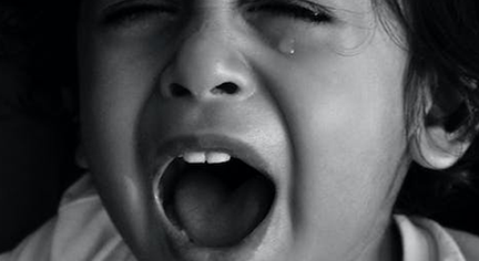 A child screaming with tears on her eyes
