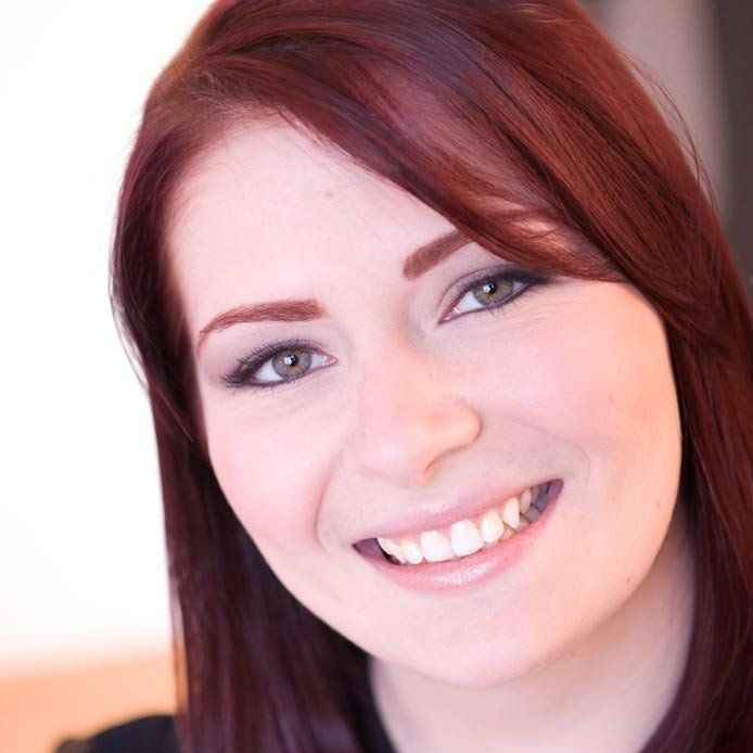 Elyse O'Shaughnessey, A smiling red haired woman wearing a black blouse