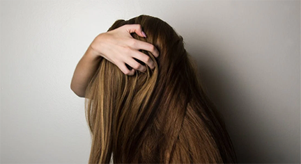 A woman holding her long brown hair