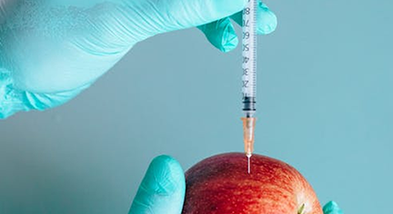 A syringe inserted in an apple