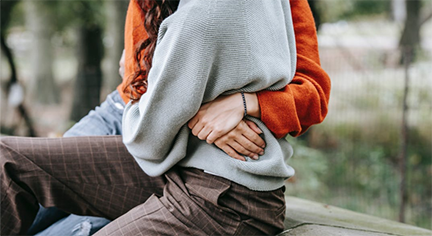 A man hugging a woman in her waist