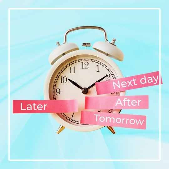 white old fashion alarm clock with pink sticky tape on dial saying tomorrow, later, next day