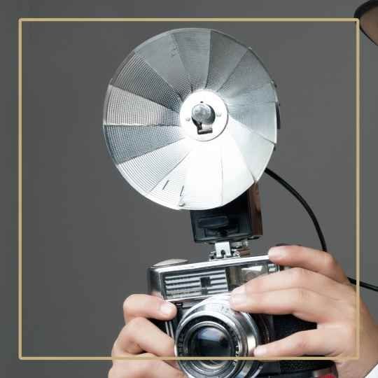 old fashion camera with flash bulb on a brown-grey background