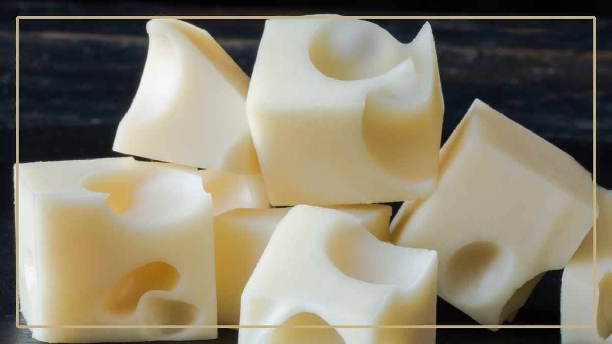 Swiss cheese cubes stacked together on a black background