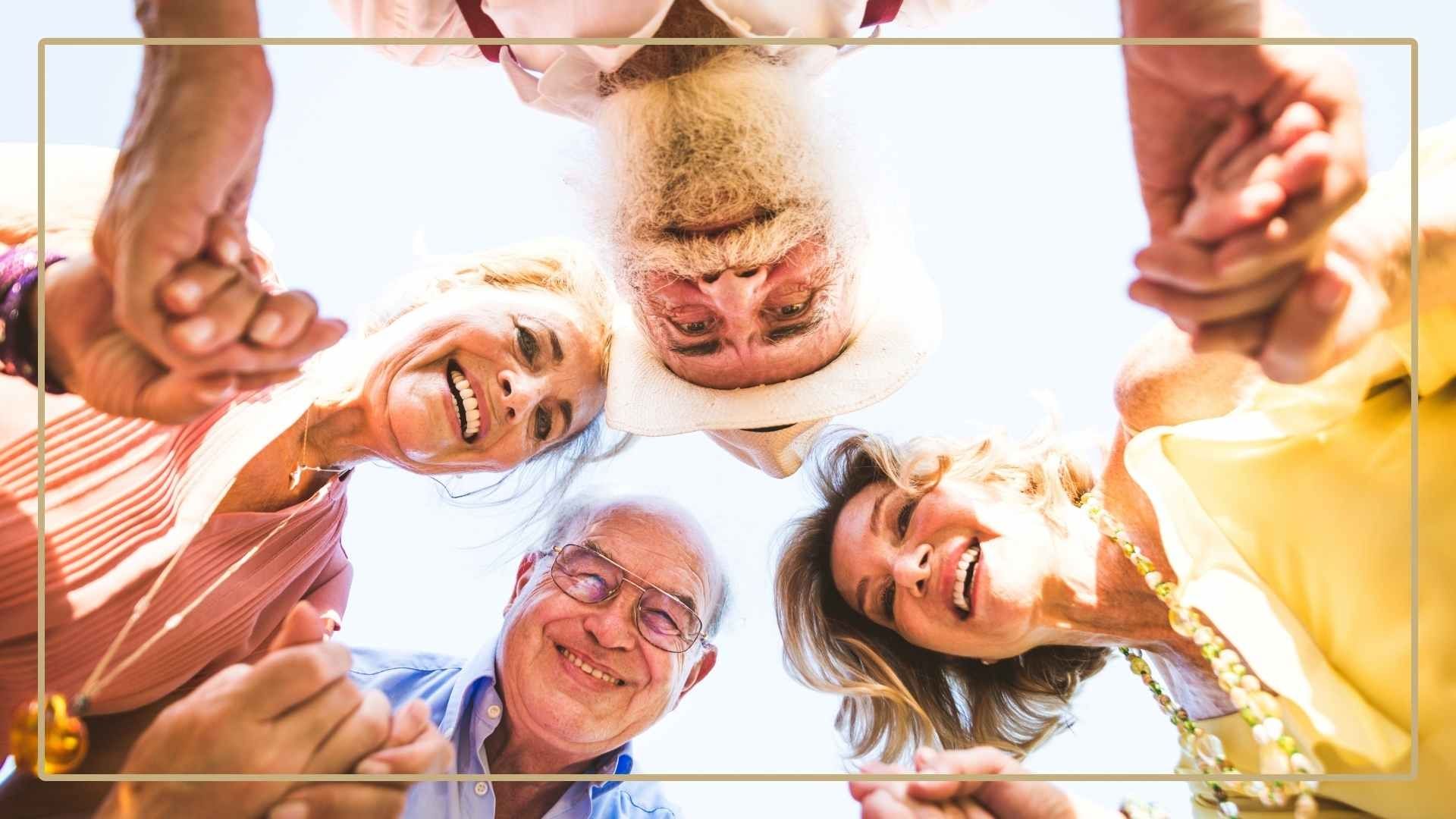 multi-generational family holding hands in a circle looking down at the camera