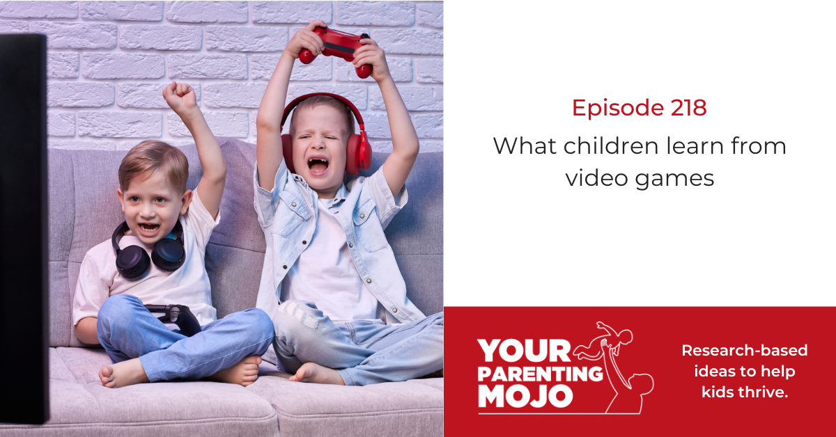 Two young boys with headphones celebrate excitedly while gaming on a couch, one holding a red controller in triumph