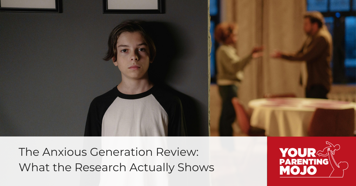 A young person with shoulder-length brown hair wearing a black and white baseball-style shirt stands in what appears to be a home interior, with adults visible but blurred in the background