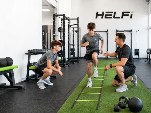 Age-appropriate youth training at Helfi gym in Woolloongabba Brisbane with a trainer supervising teenagers during safe movement and agility exercises.