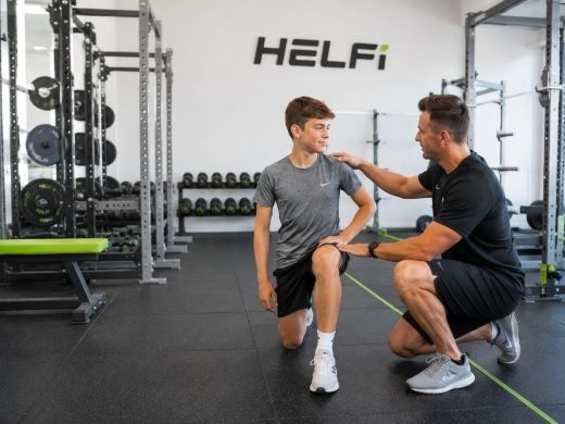 Youth fitness assessment at Helfi gym in Woolloongabba Brisbane with a trainer checking movement control and training readiness for a teenager.