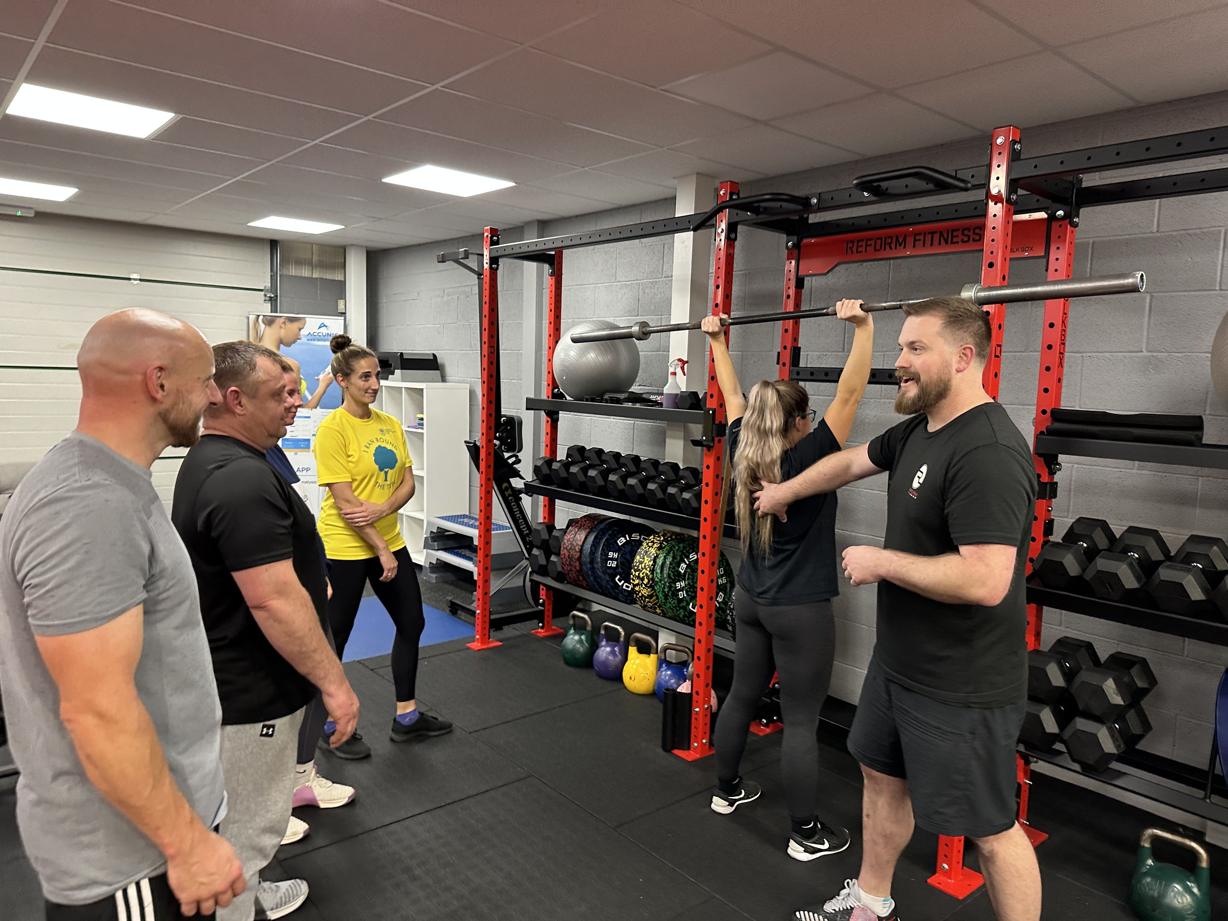 Reform Fitness member training with support from a coach