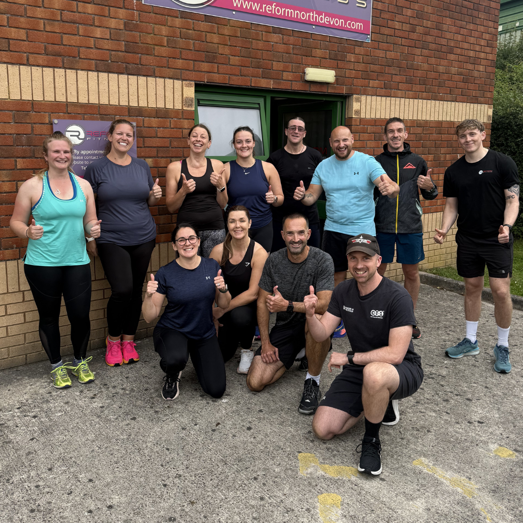 A group of people stood outside a gym in workout clothing.