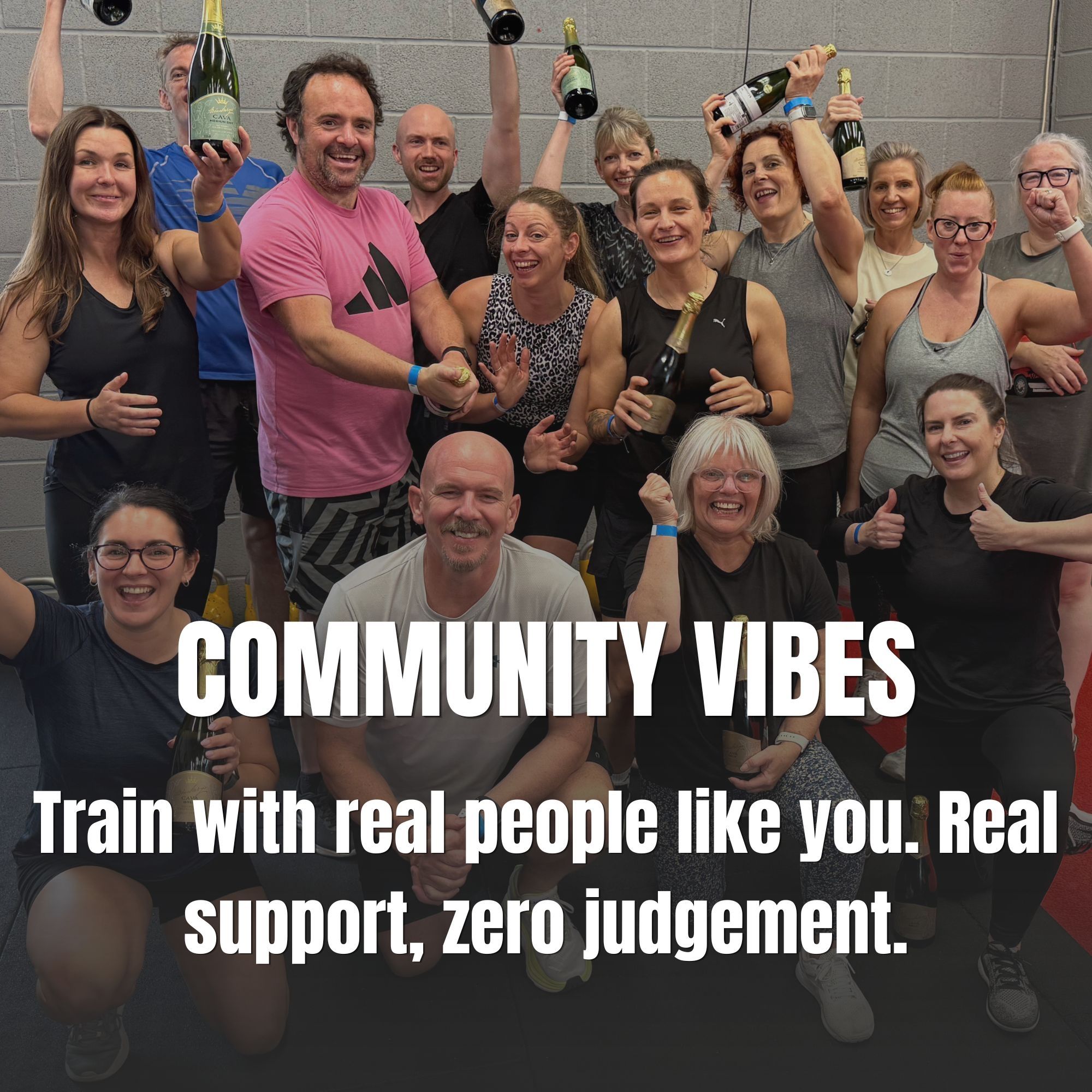 A group of gym goers holding champagne and smiling at the camera.
