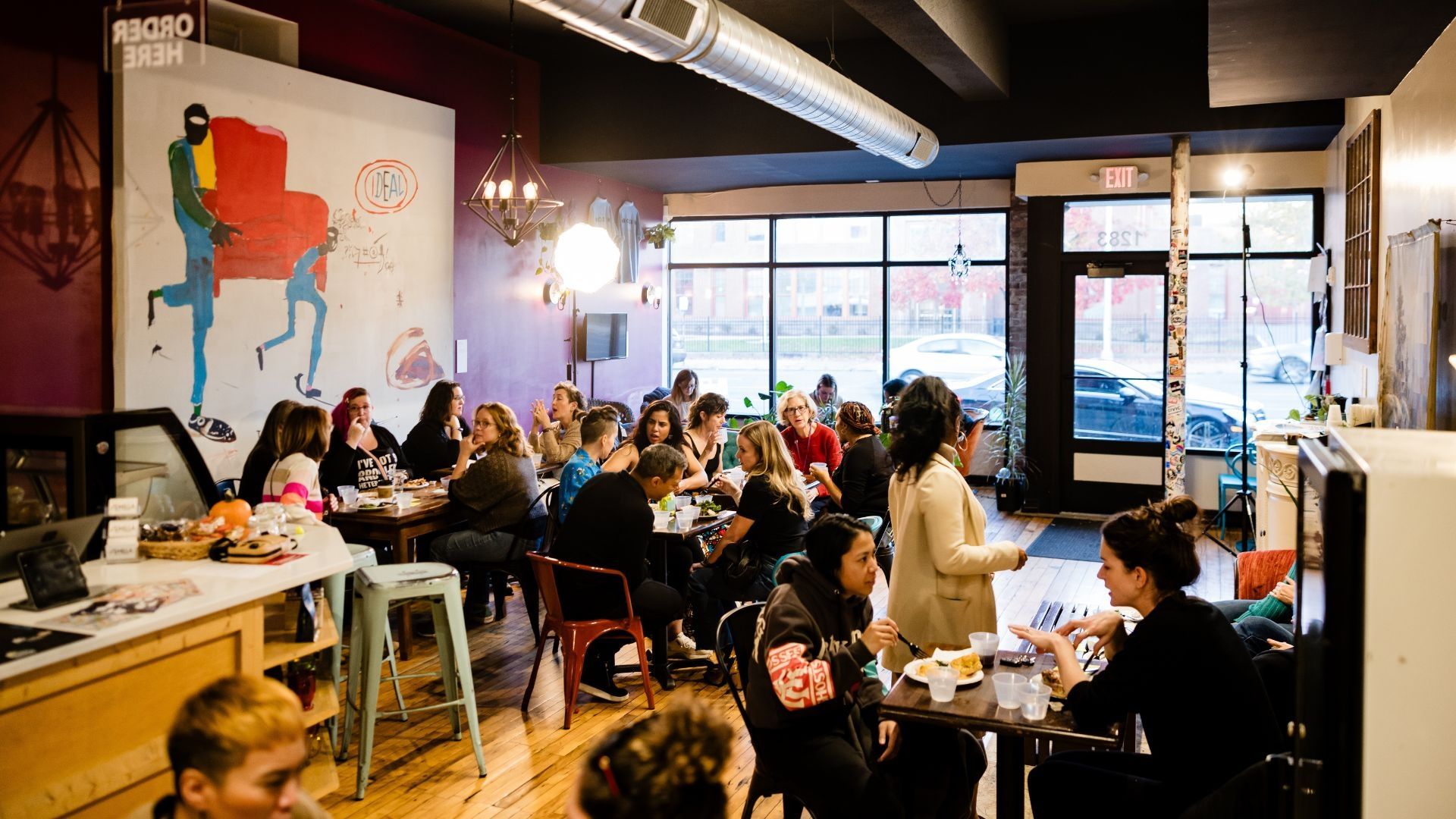 A large group of people dine and network at Samila Cafe in Hartford, Connecticut as a part of The Coaches Forum. 