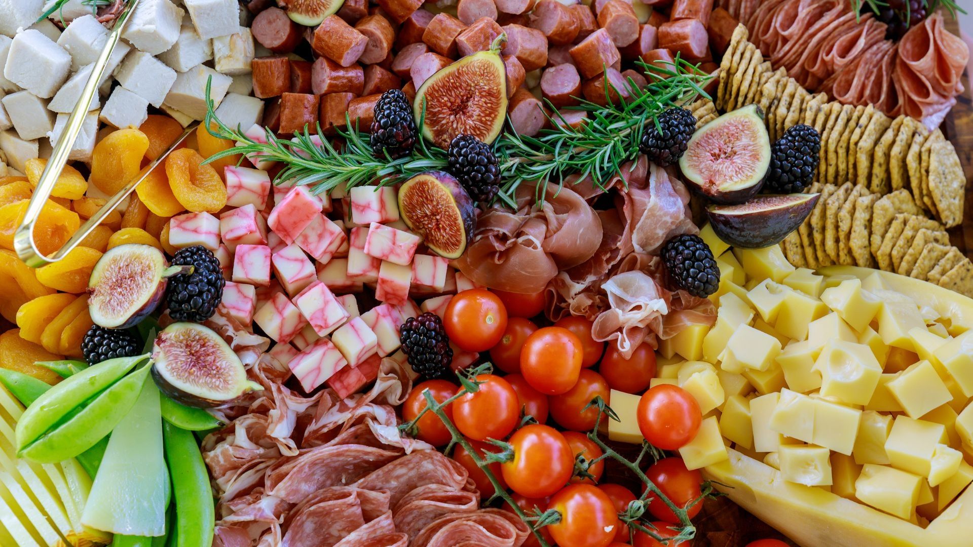 A charcuterie spread of cheese, meats, and fruits.