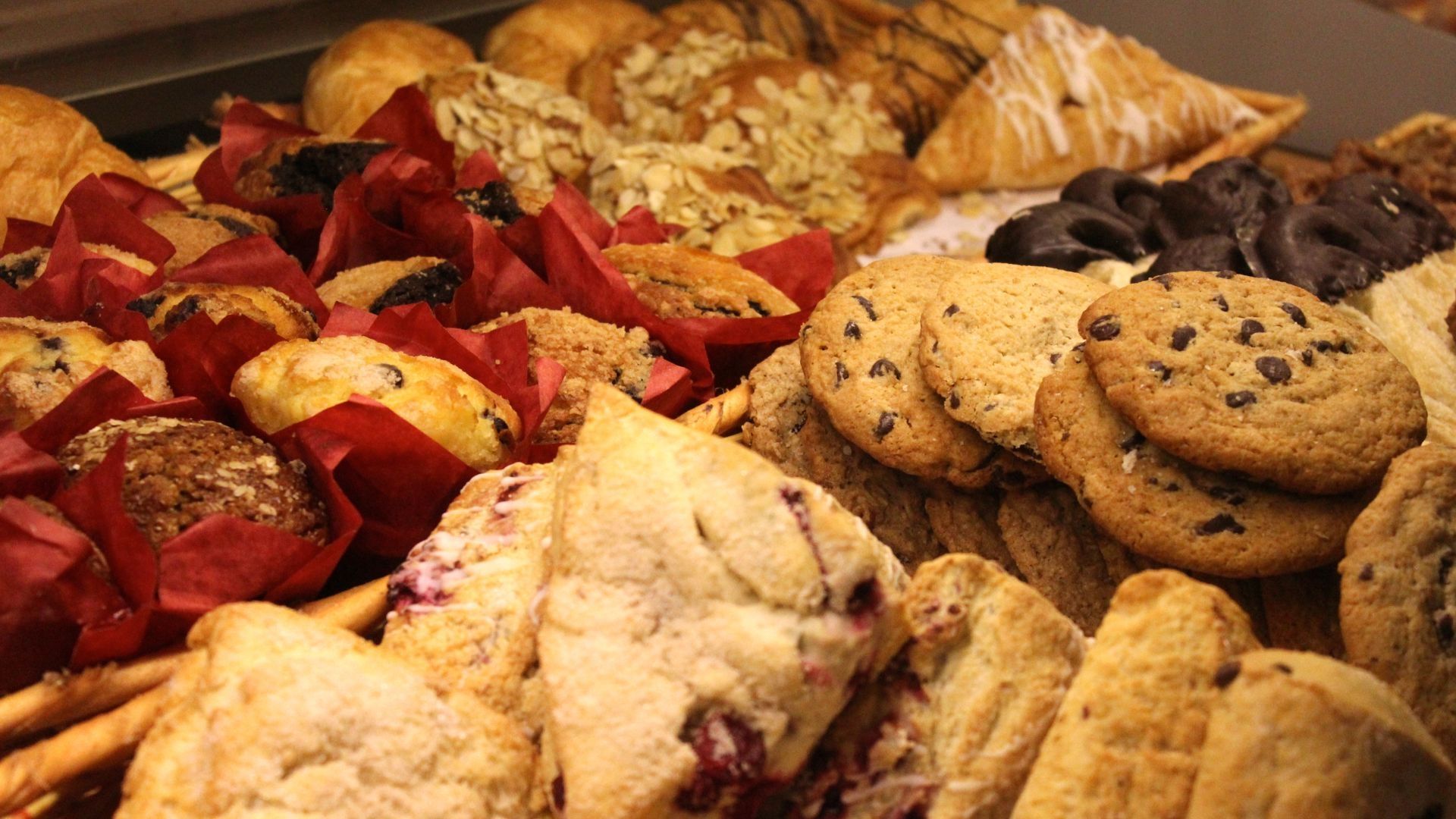 A delicious spread of baked goods including cookies, scones, muffins, and other pasteries.
