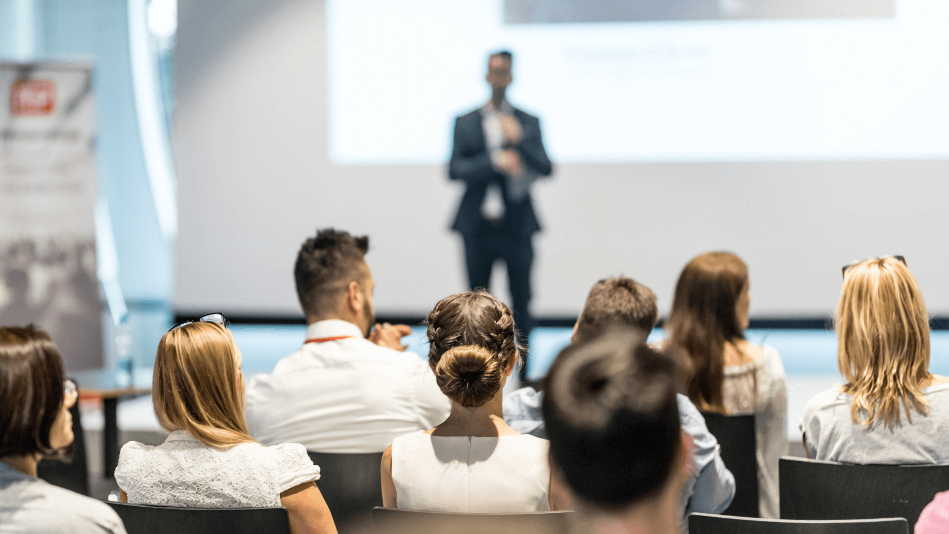 An engaging speaker at a property investment masterclass, with an audience of eager learners, highlighting the value of continuous education.
