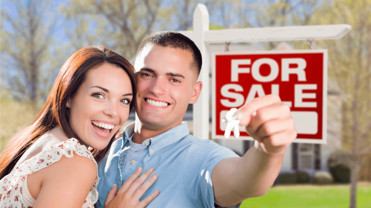 First-home buyers smiling outside their new house