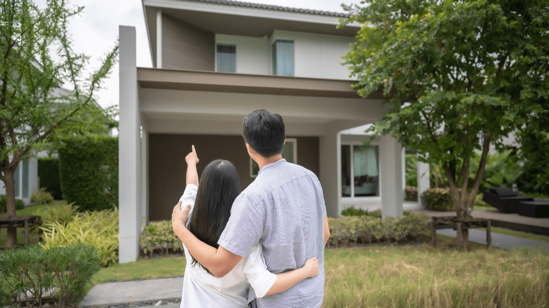 An inspirational image showing a happy couple or individual in front of their newly acquired property, representing the achievement of investment goals.