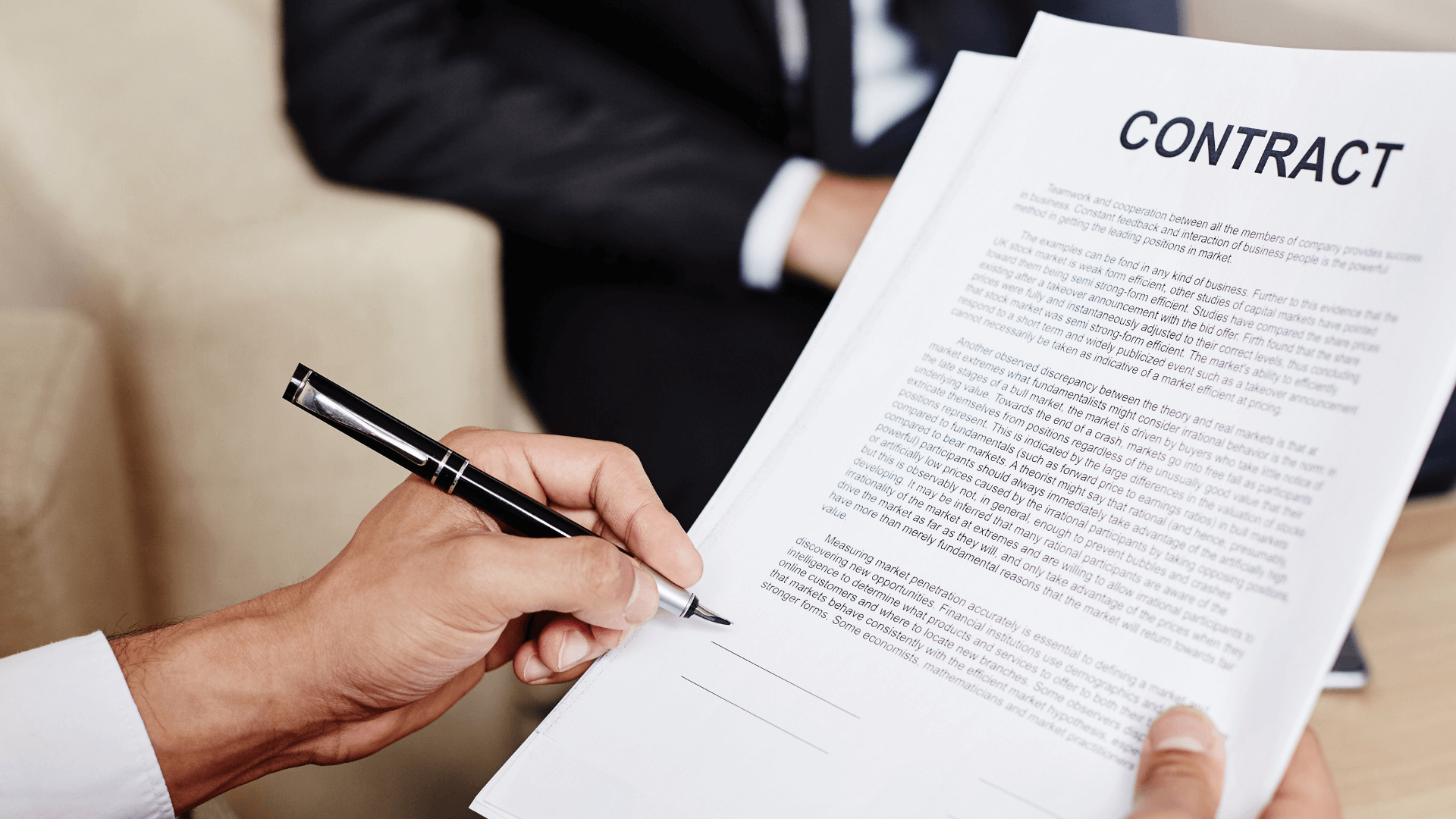 A close-up of hands signing a commercial property purchase agreement, capturing the crucial moment of commitment.