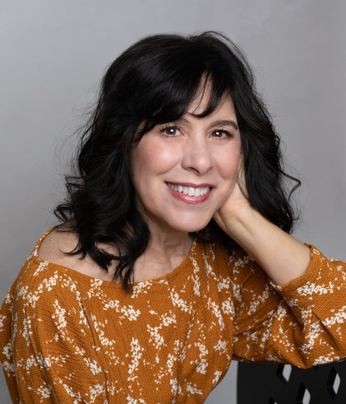 Businesswoman smiling confidently in a studio setting for her professional headshot.
