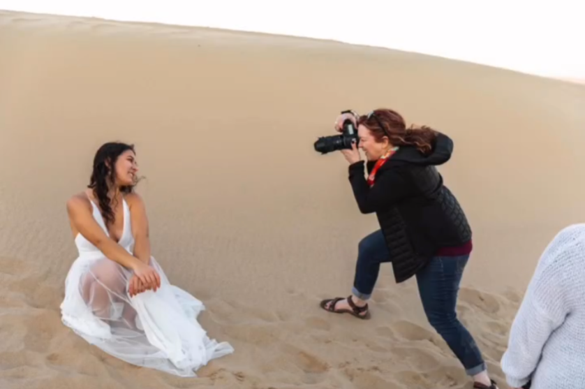 a senior and photographer taking a session in the dessert.