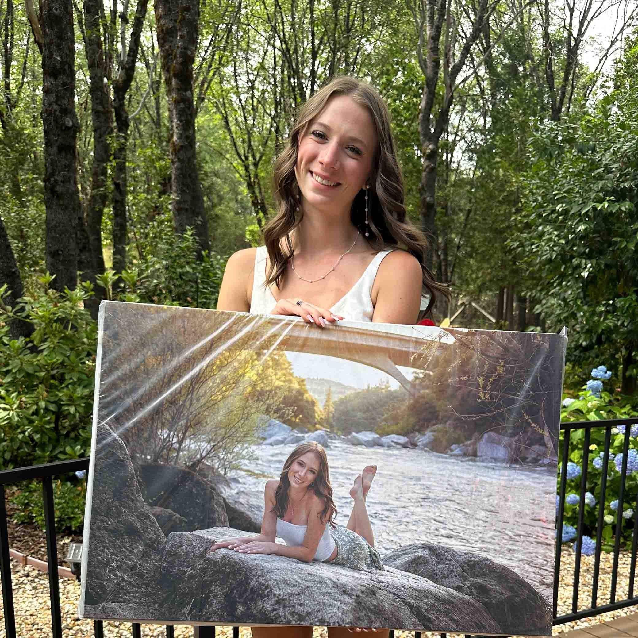 portraits of senior holding her photo in a canvas smiling