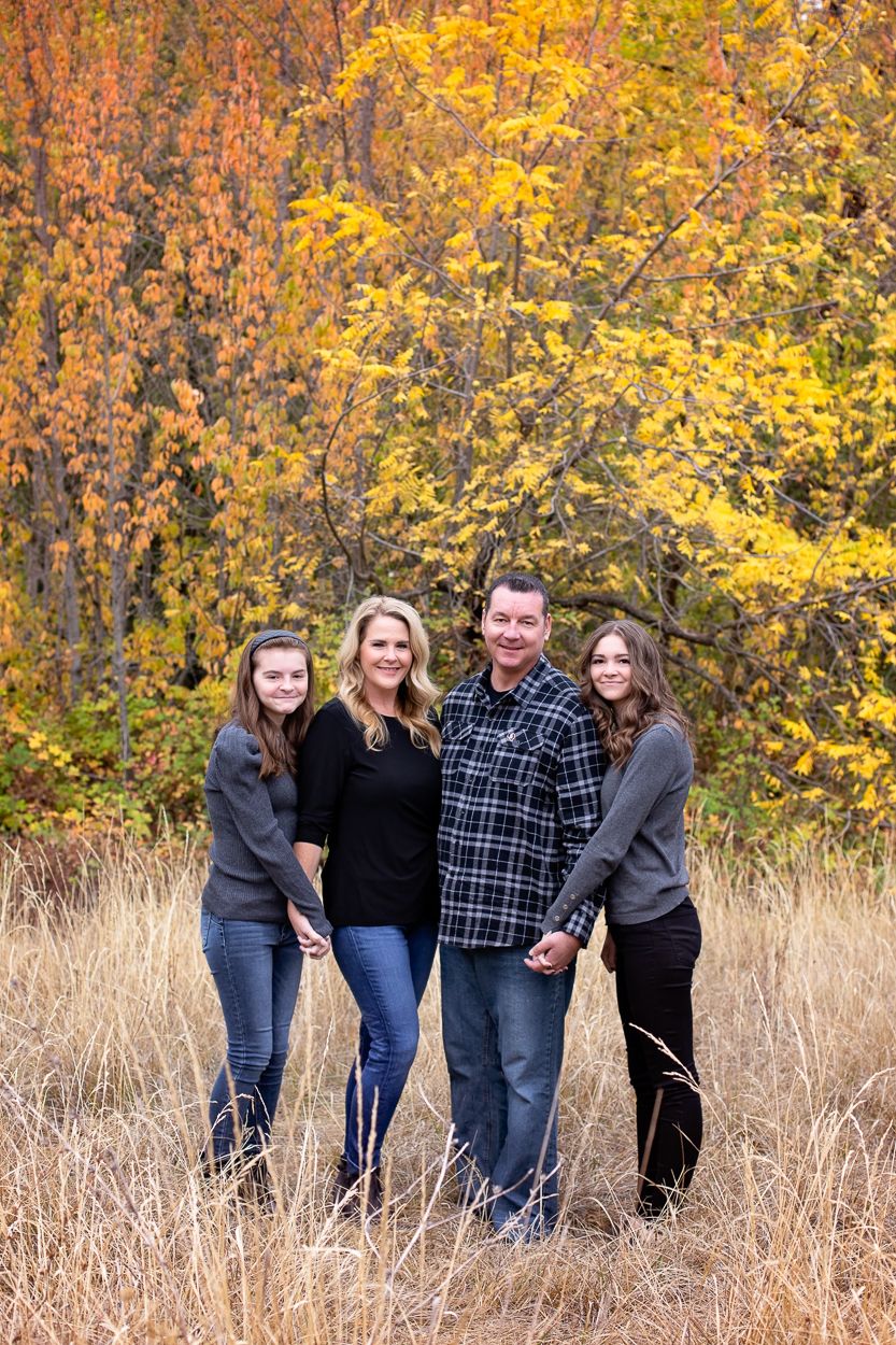 Smiling family of four posing together outdoors during a professional photo session in Grass Valley, California.