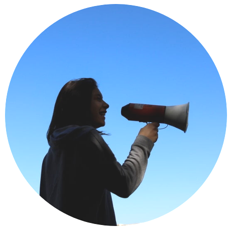 A woman holding a megaphone against a blue sky backdrop, conveying a powerful message.