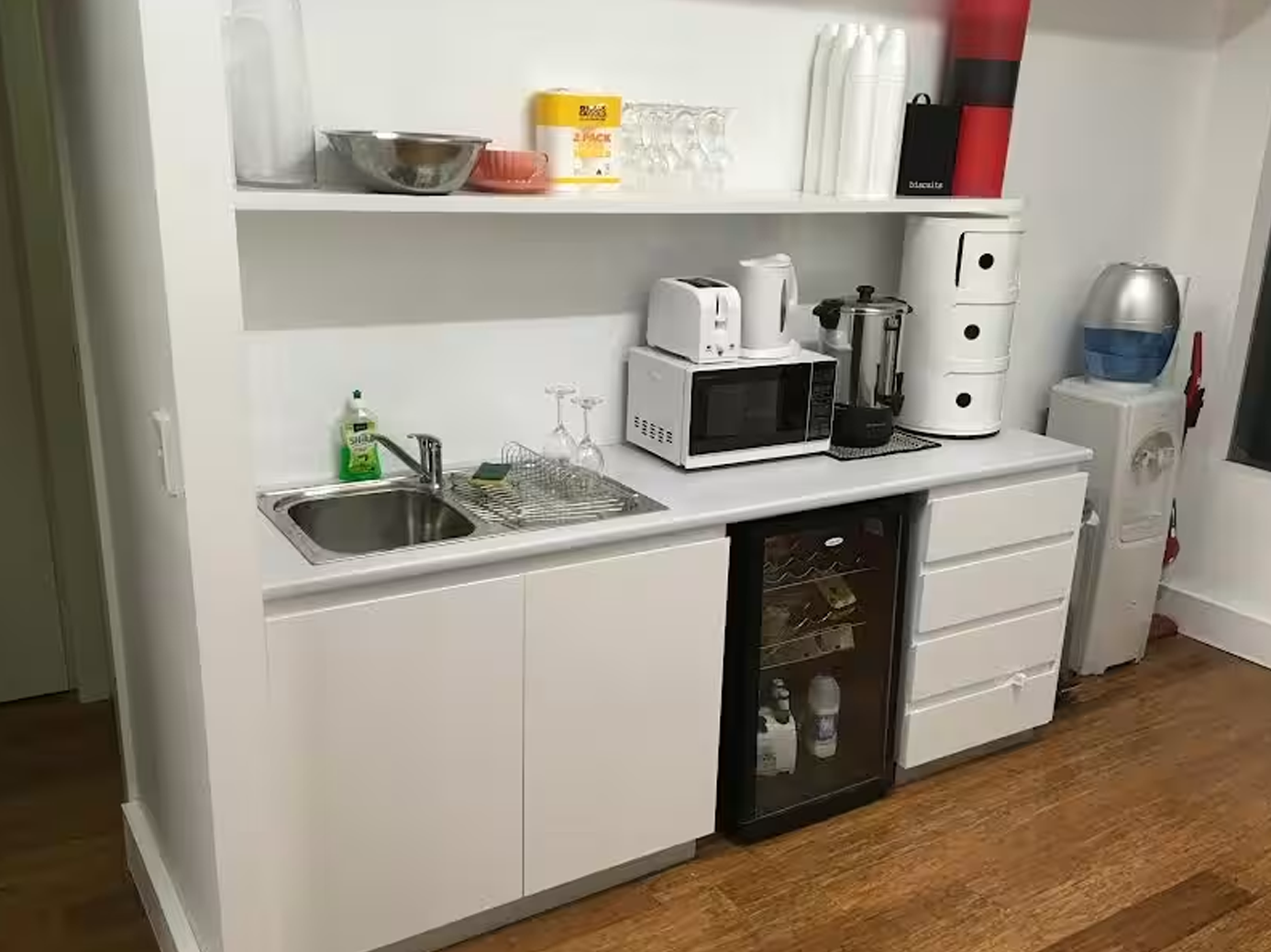 Modern kitchen featuring fridge, microwave, and sink. Darlinghurst Venue hire