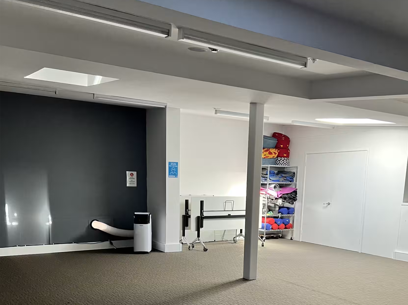 Simple room with a white wall and a closed door. Darlinghurst Venue hire