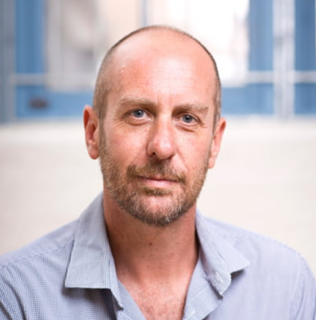 Glen Hamilton - A bald man wearing a blue formal polo