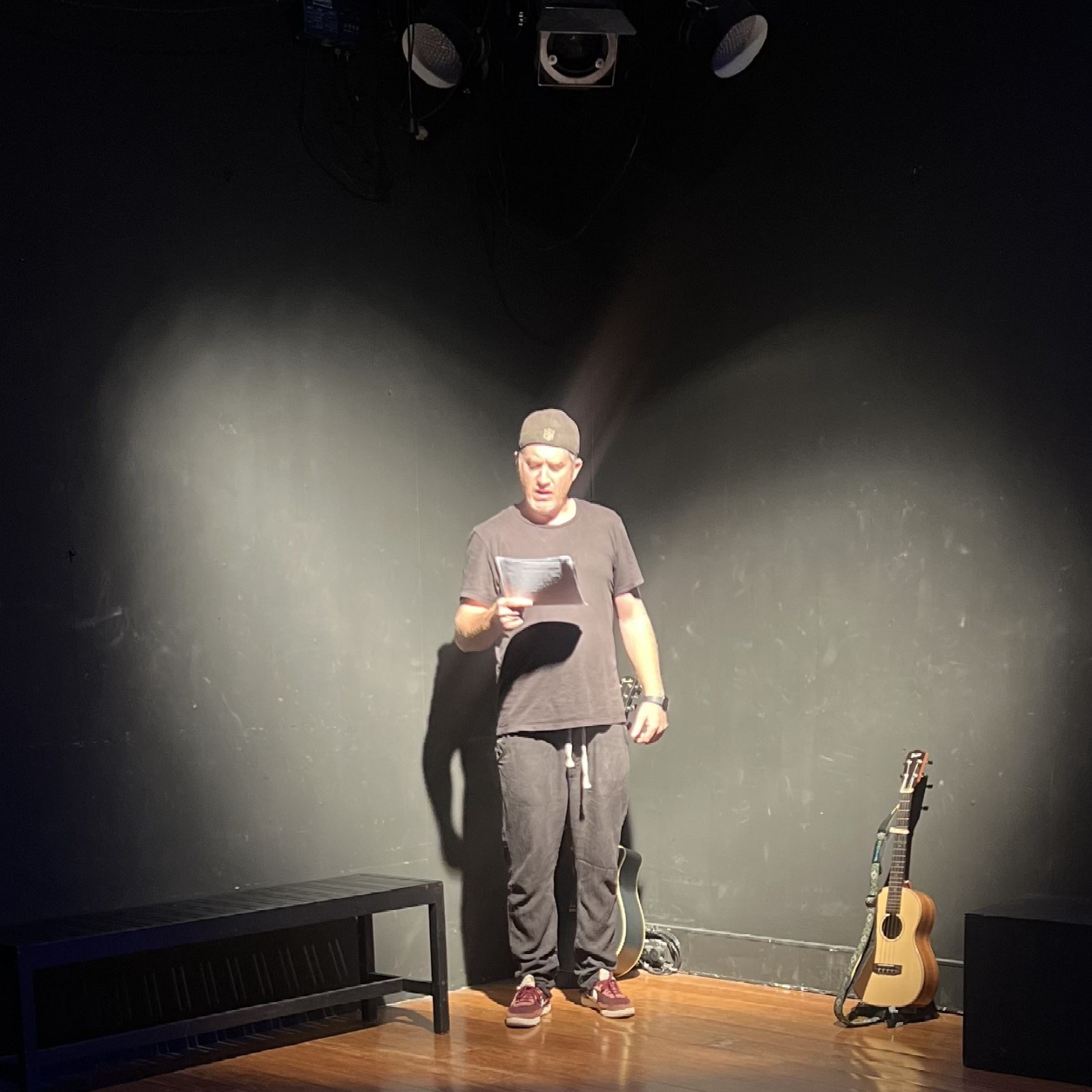 Male and female standing in front of dark background while holding hands