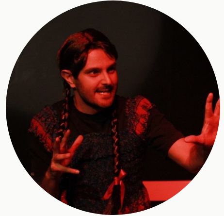 A long haired guy acting in stage with a braided hairstyle