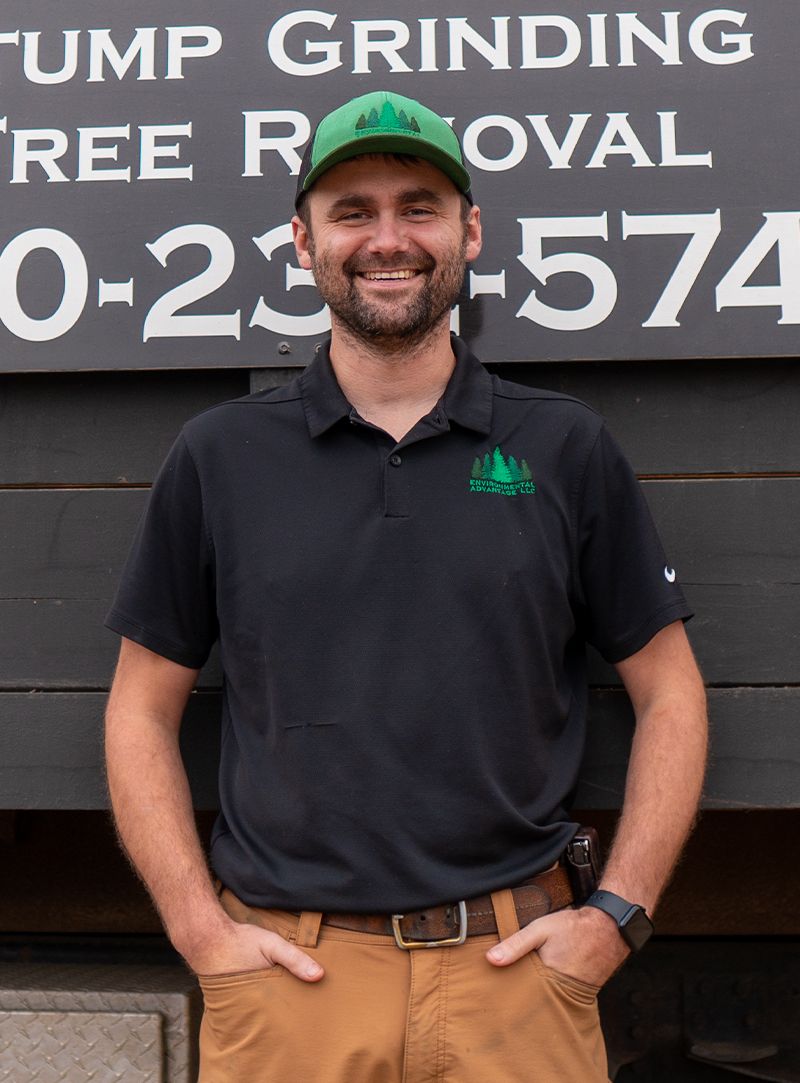 Zach, founder and ISA certified arborist at Environmental Advantage, standing in front of a tree services truck, representing expert organic tree care in Minnesota and North Dakota.