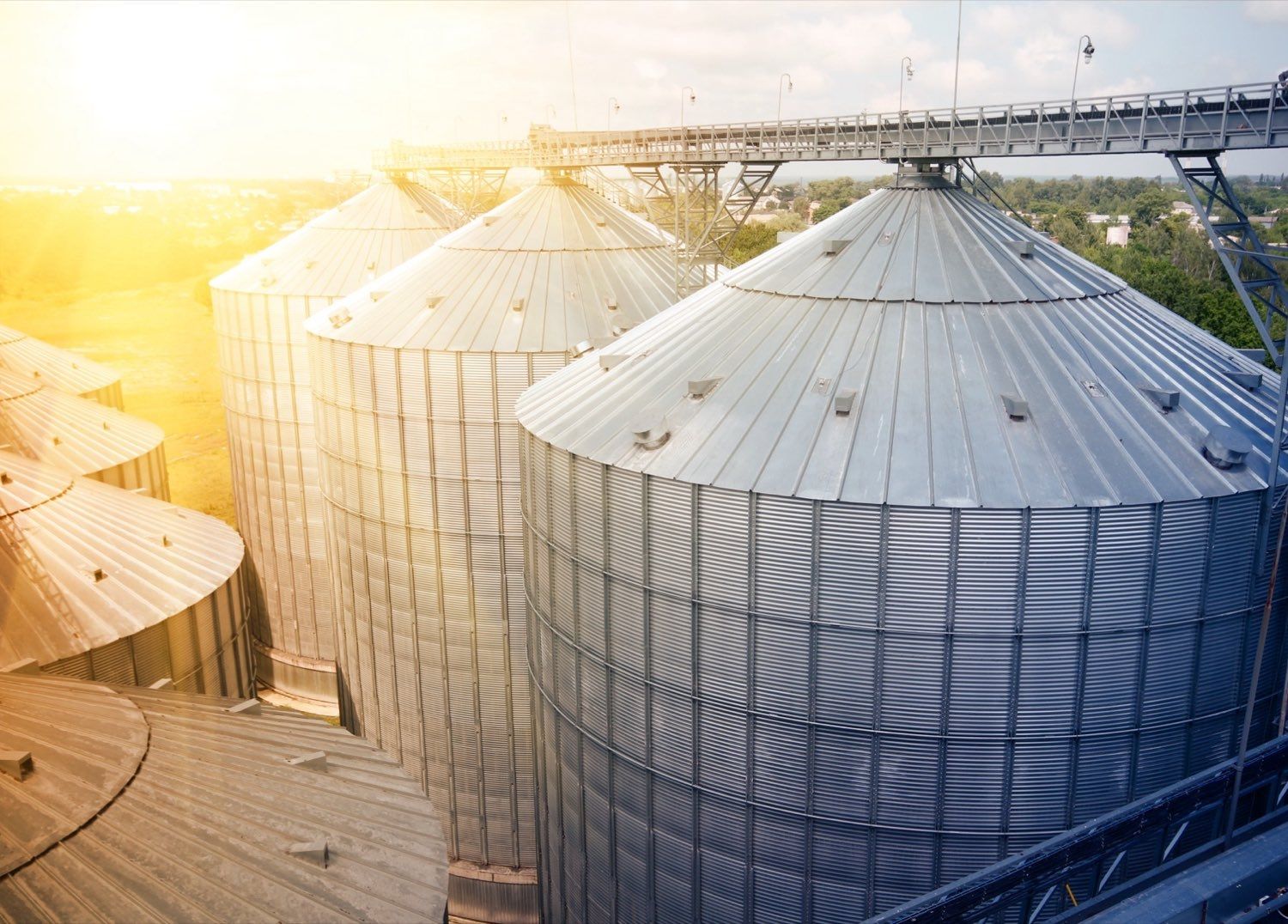Aerial view of grain silos and storage across farmland at golden hour