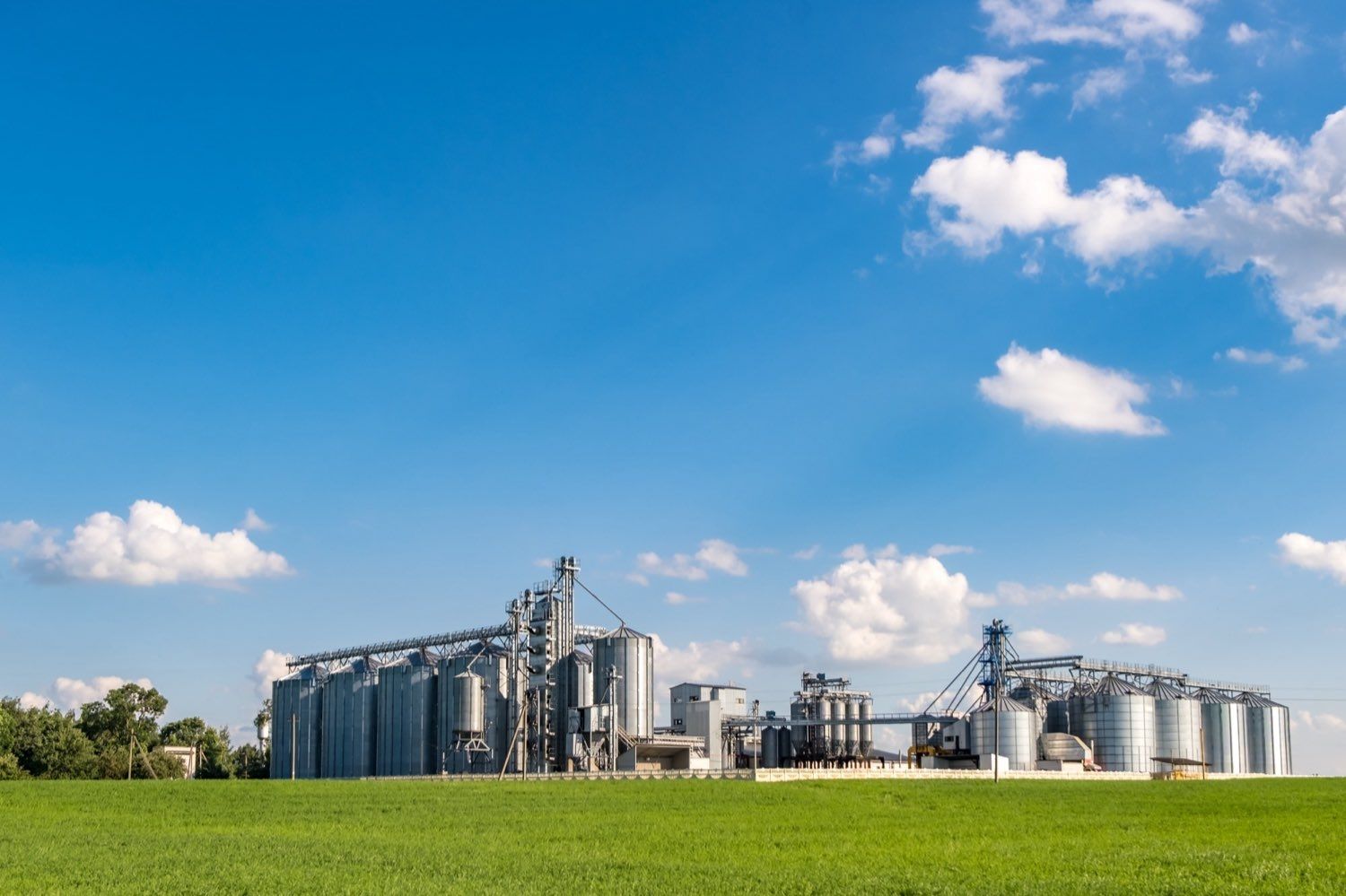 A commercial grain elevator and storage facility under a wide sky