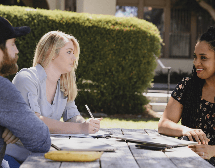 Young entrepreneurs at a table outside with laptops.