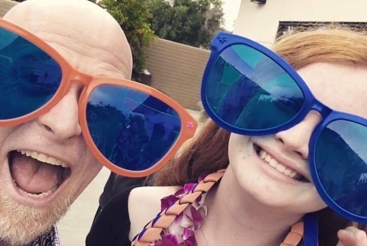 A father and young daughter wearing big, funny sunglasses