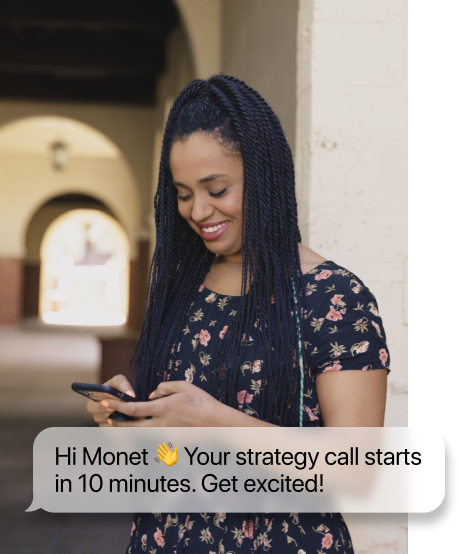 A woman smiling whlie looking at her phone