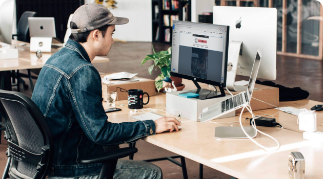 An image of a person sitting at a desk, looking at a computer, working in the Ontraport app