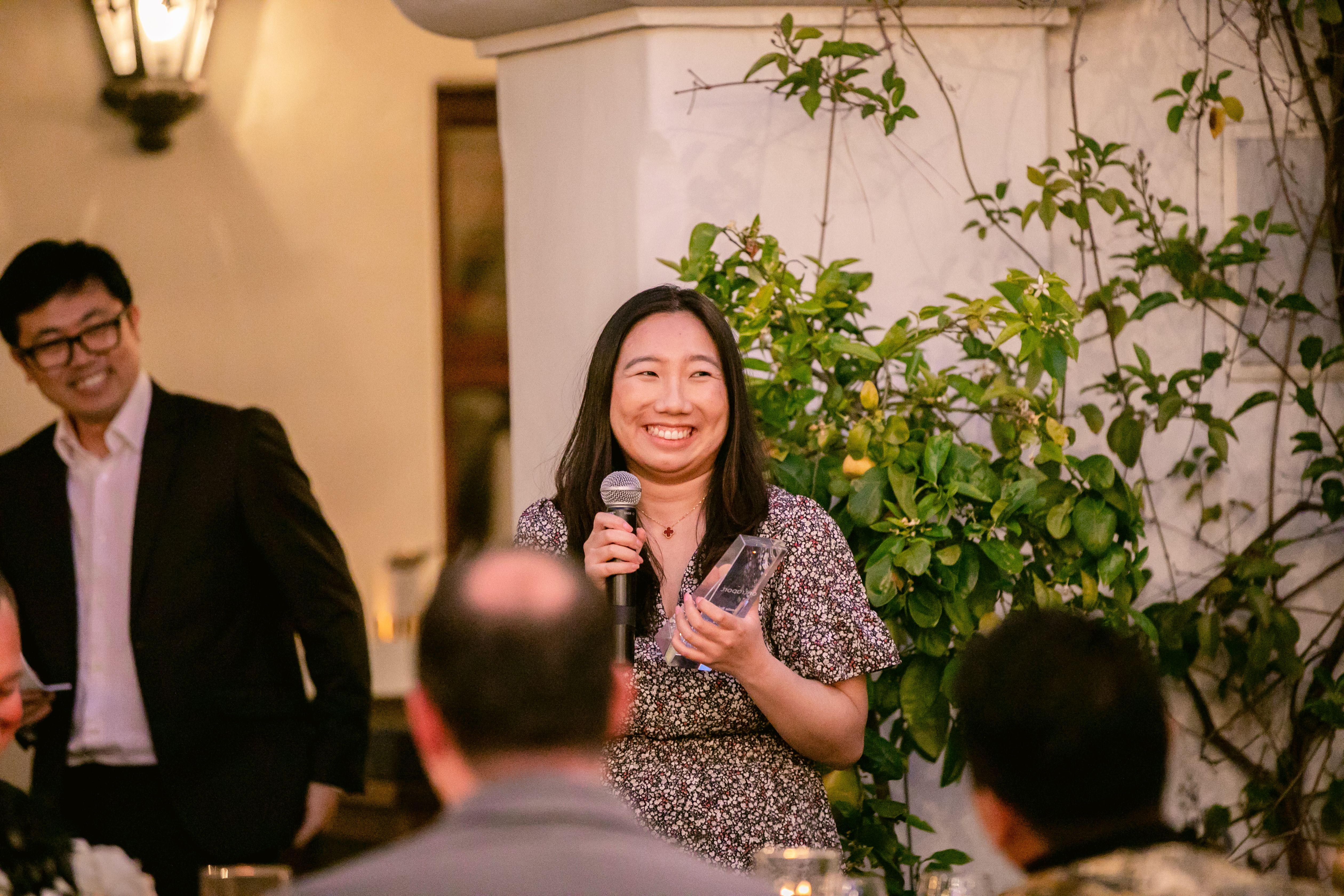 A woman sitting at a desk on a zoom meeting.