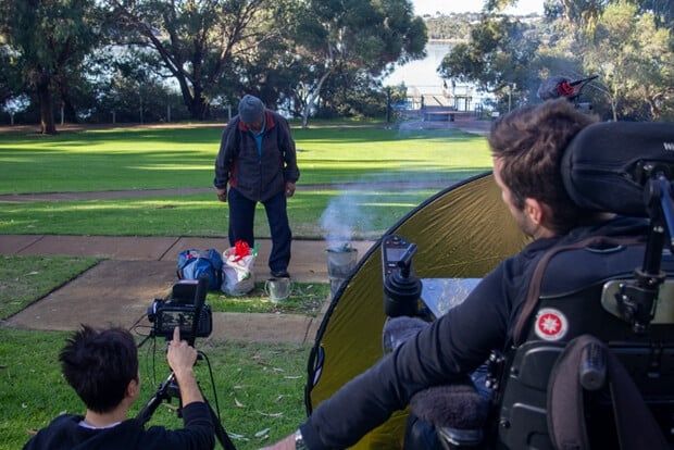 Photo of filmmaker Marty Stevens, filming a scene in a park.